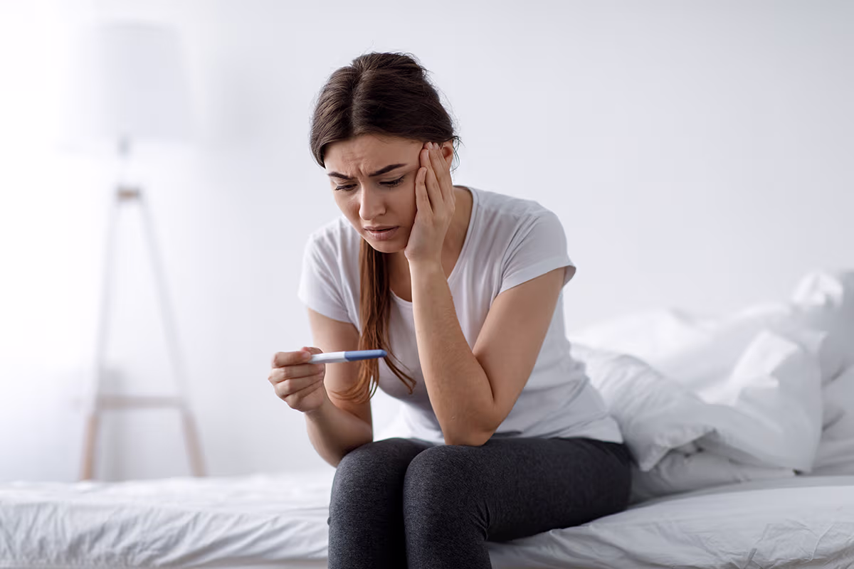 Low birth rate hero image showing a woman looking at a pregnancy test